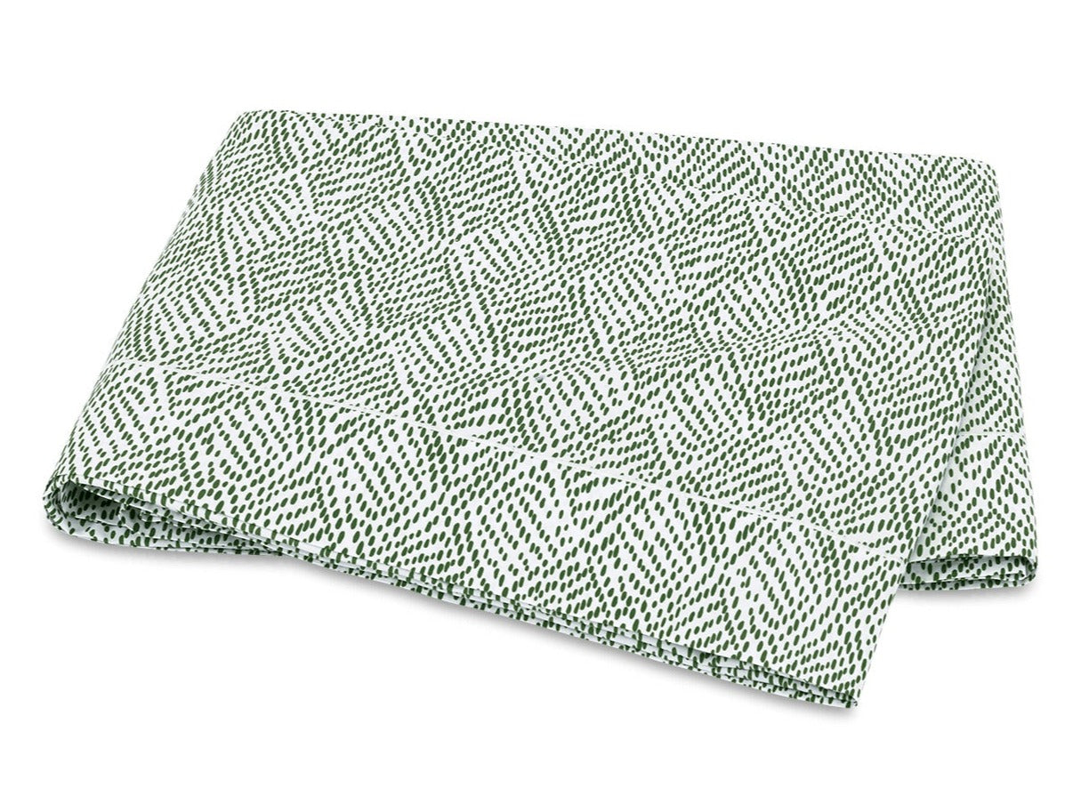 The Duma Diamond Bedding Collection by Matouk is displayed against a plain background, featuring folded white Egyptian cotton percale adorned with a green, leaf-like dotted geometric pattern.