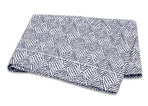 A folded rectangular blanket from the Matouk Duma Diamond Bedding Collection, featuring a blue and white geometric diamond pattern in a distinctive Schumacher design and crafted from luxurious Egyptian cotton percale, displayed on a white background.