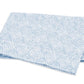A folded blue and white towel from the Matouk Duma Diamond Bedding Collection, featuring a striking geometric pattern, is displayed on a plain white background.