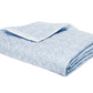 The Matouk Duma Diamond Bedding Collection in Sky, made from OEKO-TEX® certified Egyptian cotton, features a light blue and white geometric design and is displayed folded against a white background.