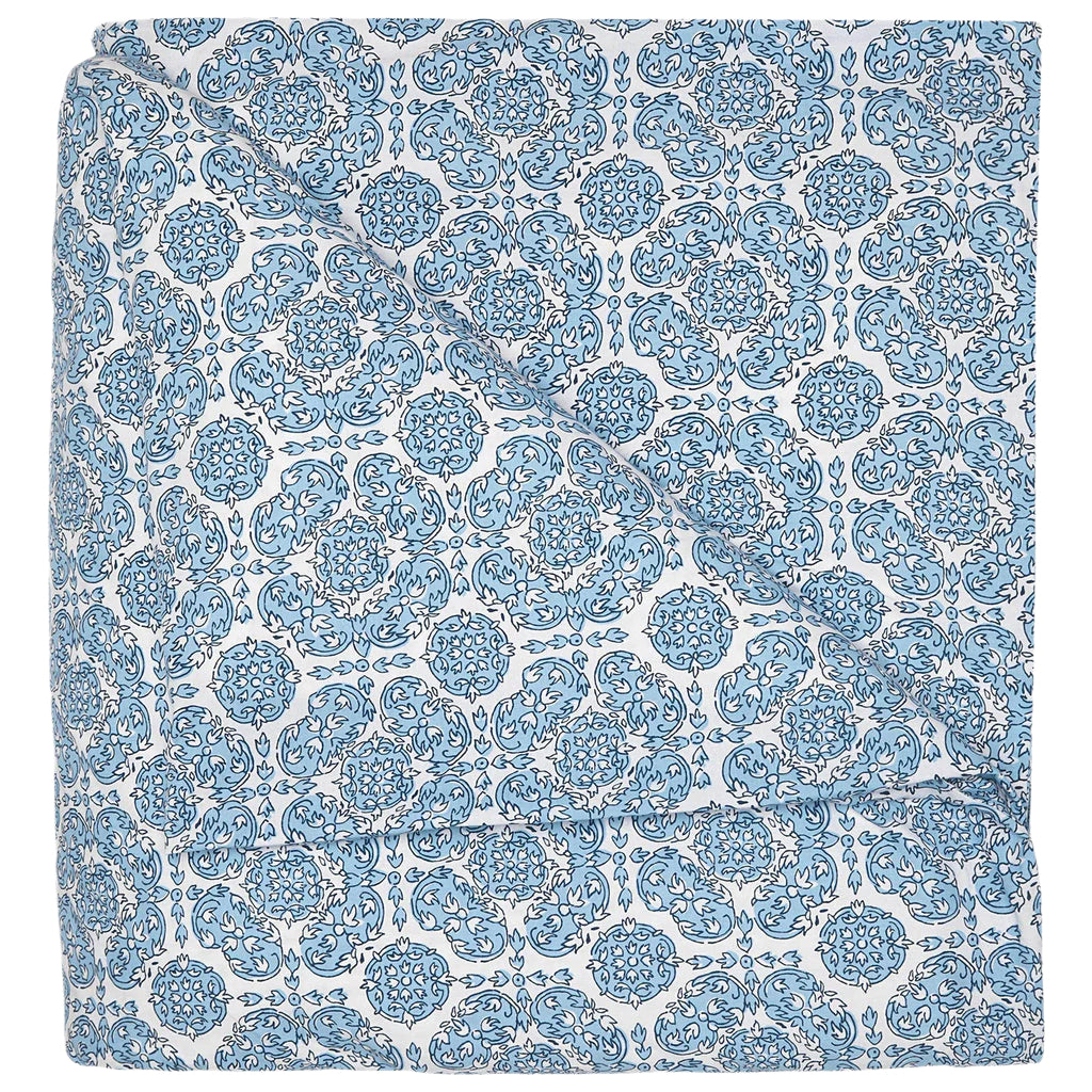 The Sahil Indigo Bedding Collection by John Robshaw features a folded blanket with an intricate blue and white floral pattern, reminiscent of Mughal garden bedding, displayed on a white background.
