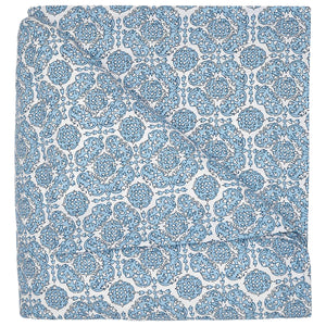 The Sahil Indigo Bedding Collection by John Robshaw features a folded blanket with an intricate blue and white floral pattern, reminiscent of Mughal garden bedding, displayed on a white background.
