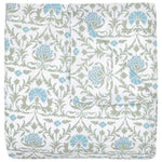 The Vidya Leaf Bedding Collection by John Robshaw is a folded quilt with a white background, featuring blue and sage floral and vine patterns inspired by a serene garden.