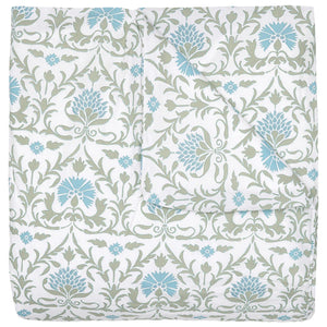 The Vidya Leaf Bedding Collection by John Robshaw is a folded quilt with a white background, featuring blue and sage floral and vine patterns inspired by a serene garden.