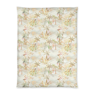 The Christian Fischbacher Satin Oasis Bedding Collection features a rectangular blanket with a pastel tropical landscape of palm trees and plants—ideal for luxury bedding and an oasis-inspired linen look.