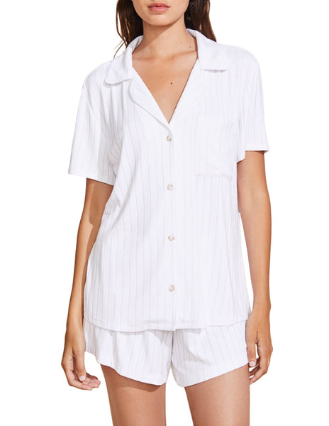 A woman wearing a white striped short-sleeved pajama set in TENCEL™ Modal, consisting of a buttoned shirt and shorts, the Eberjey Gisele Rib Relaxed Short PJ Set.