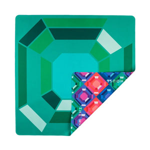 The Mahjong House Double-Sided Travel Mahjong Mat features a square, gem-patterned green surface with one corner flipped to show a vibrant geometric design and the brand name "HOUSE.