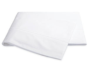 The Essex Bedding Collection in white by Matouk features folded sheeting with a subtle decorative line and satin stitch embroidery near the edge, shown on a plain white background.