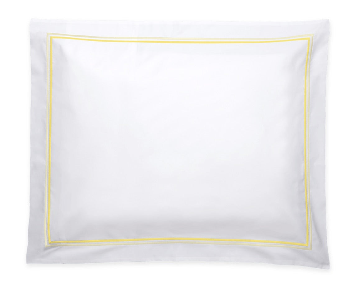 A white rectangular pillowcase from the Matouk Essex Bedding Collection, crafted from luxurious Sierra sheeting and featuring a simple yellow border with elegant satin stitch embroidery, is neatly displayed against a white background.