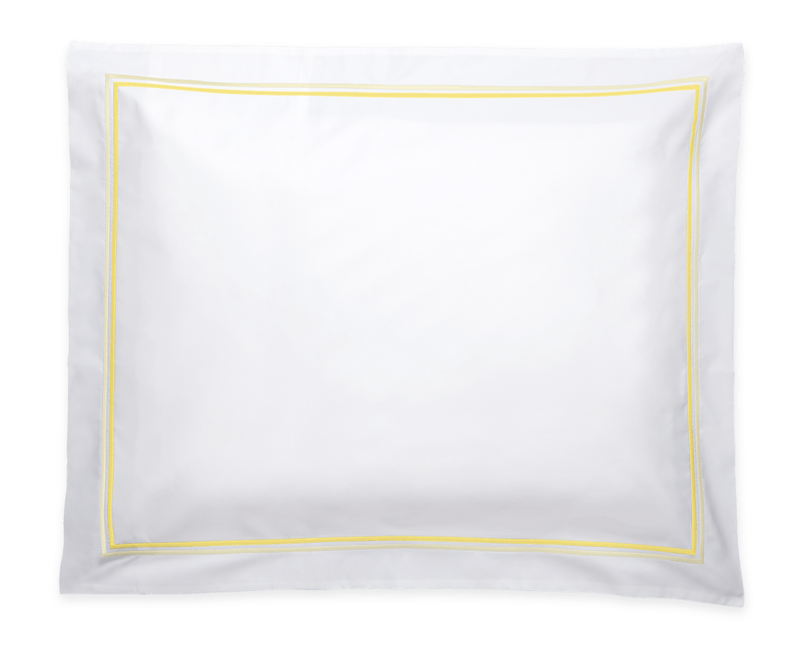 The Essex Lemon Bedding Collection by Matouk features a white rectangular pillow with a yellow border, crafted from soft Sierra sheeting and inspired by European hotel bedding, shown on a plain background.