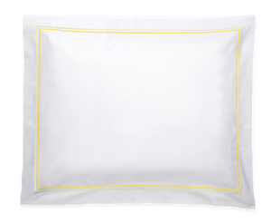 The Essex Lemon Bedding Collection by Matouk features a white rectangular pillow with a yellow border, crafted from soft Sierra sheeting and inspired by European hotel bedding, shown on a plain background.