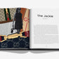 An open copy of "Fashionphile: The Book of Iconic Bags" by Assouline reveals a section titled "The Jackie GUCCI," with text, a black-and-white photo of a woman, and images of pre-owned designer bags and hardware on the left page.