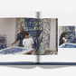 An open book titled "Father and Child" by Assouline shows photos of a father and child in an art studio, admiring large blue abstract canvases with geometric designs.