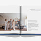 A family of five in neutral outfits poses by a vintage car in a modern white room, evoking modern fatherhood—an image from "Father and Child" by Assouline; text appears on the right page.