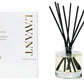 A L’Avant Collective Fresh Linen Scent Collection reed diffuser, featuring black reeds in a clear glass bottle beside its white and gold box, perfectly complements the brand’s luxurious hand soaps.
