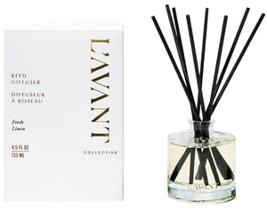 A box labeled "Fresh Linen Reed Diffuser" by L’Avant Collective sits beside a glass bottle with black reeds in scented liquid, offering a fresh linen fragrance.
