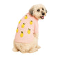A fluffy dog faces away, looking back at the camera, wearing the Found My Animal Icon Sweater—a cozy pink dog sweater featuring stylish yellow fruit designs.