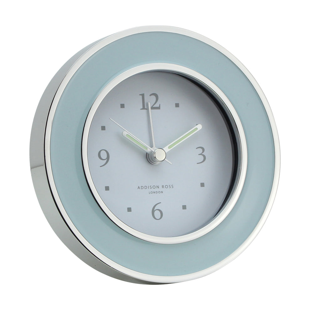 The Addison Ross Round Alarm Clock features a silver enamel frame, light blue border, and white face showing 10:10—ideal for adding elegance to your bedside table.