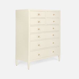 The Jarin Tallboy by Made Goods is a cream linen dresser with eight drawers, each with a round knob and smooth European glides, standing on four tapered legs against a white background.