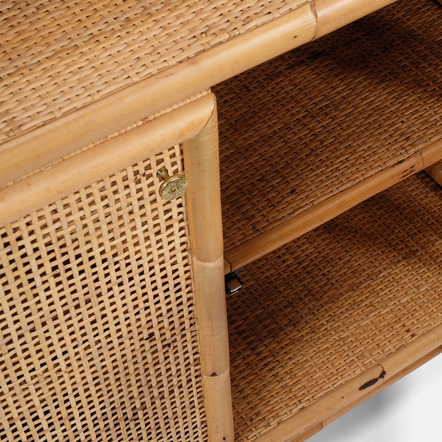 Close-up of the Made Goods Lainey 3 Piece Bookcase Set, crafted from bamboo and woven rattan, featuring doors with brass latches and interior shelving—its refined lines, textures, and subtle pagoda-inspired silhouette make it a striking statement centerpiece.