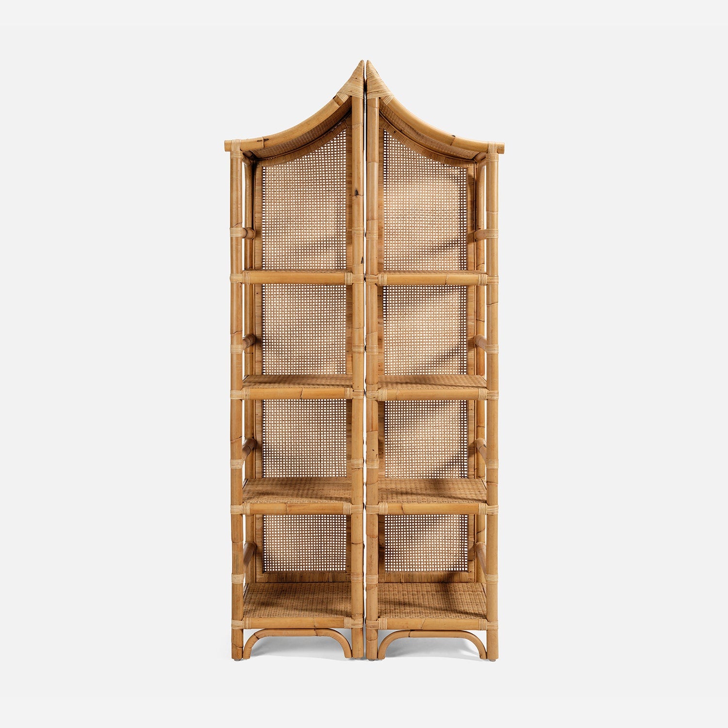 The Lainey 3 Piece Bookcase Set by Made Goods features tall, freestanding shelving units crafted with a curved, pagoda-inspired top and woven cane panels on the sides and back. With multiple open shelves, this set serves as a stunning centerpiece for any room.