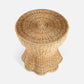 The Nevis Side Table by Made Goods features a round woven wicker design with a tapered silhouette and a flared, scalloped base, shown from above against a plain white background.