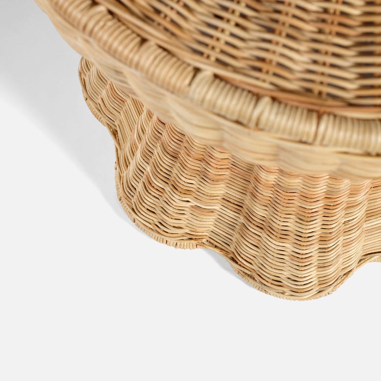 Close-up of the Made Goods Nevis Side Table, featuring a woven wicker design, scalloped edge, and tapered silhouette against a white background.