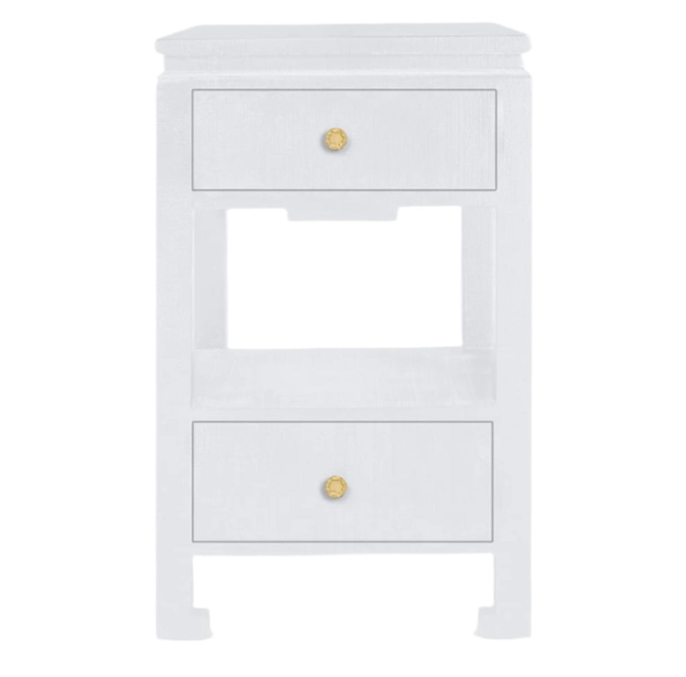 The Wylder Nightstand Collection by Made Goods features an elegant white wood nightstand with two drawers, gold knobs, and a shelf between the drawers.