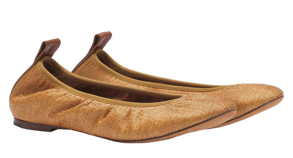A pair of elegant light brown Lanvin Raffia Ballerina flats with elastic edges and brown pull loops at the heel, shown from a side angle. These versatile shoes effortlessly complement any casual outfit.