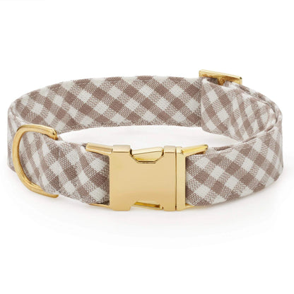 The Mushroom Brown Gingham Dog Collar by The Foggy Dog features a beige and white gingham pattern with a gold metal buckle and D-ring, displayed on a white background.