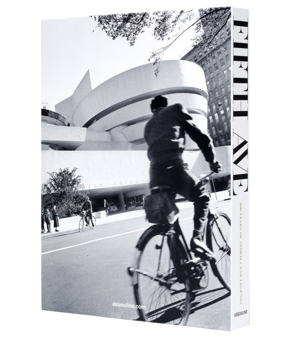 A black and white photo of a cyclist passing the Guggenheim Museum on New York’s iconic Fifth Avenue, featured on the cover of "5th Avenue," a history book by Assouline.