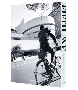 A black and white photo of a cyclist passing the Guggenheim Museum on New York’s iconic Fifth Avenue, featured on the cover of "5th Avenue," a history book by Assouline.