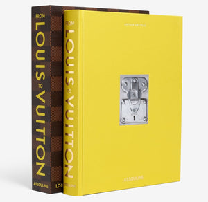 Two "From Louis to Vuitton" books by Assouline—one featuring a yellow cover and the other in a brown and gold Damier-style case—stand upright side by side.