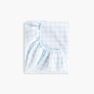 Gooselings Picnic Gingham Blue Crib Sheet: an extra soft, OEKO-TEX certified cotton sateen crib sheet in light blue and white gingham with elastic edges, shown folded against a plain white background.