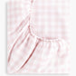 The Gooselings Picnic Gingham Pink Crib Sheet, made of pink and white cotton sateen with elastic edges, is shown folded against a plain white background.