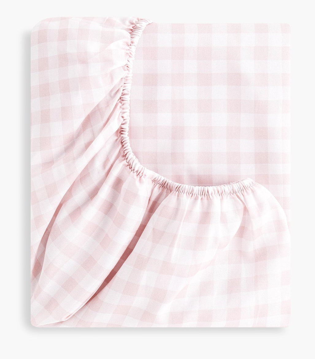 The Gooselings Picnic Gingham Pink Crib Sheet, made of pink and white cotton sateen with elastic edges, is shown folded against a plain white background.