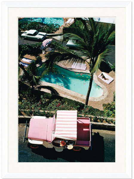 Aerial view of a small pool with lounge chairs, a palm tree, and a pink jeep with a striped canopy, evoking the Slim Aarons By Getty Images Gallery "Las Brisas," February 1 1972 by Soicher Marin.