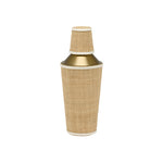 The Blue Pheasant Gable Natural/White Barware Collection features a gold cocktail shaker wrapped in woven rattan with leather trim and a matching cup, displayed against a plain white background.