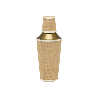 The Blue Pheasant Gable Natural/White Barware Collection features a gold cocktail shaker wrapped in woven rattan with leather trim and a matching cup, displayed against a plain white background.