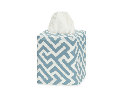 The Gabriel Tissue Box Cover Collection by Matouk features a blue and white geometric design, adding style to any bathroom. One tissue is shown protruding from the top.