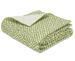The Gabriel Bedding Collection, Grass by Matouk features a folded quilt with a green and white geometric motif on one side and a white grid pattern on the other—an elegant addition to your luxury bed linens.