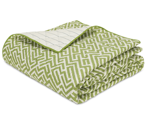 The Gabriel Bedding Collection, Grass by Matouk features a folded quilt with a green and white geometric motif on one side and a white grid pattern on the other—an elegant addition to your luxury bed linens.