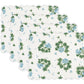 Enhance your table with Matouk's Tillett x Matouk Blue Geranium Table Linen Collection: four scalloped-edge placemats featuring a white background and a floral design of green leaves and blue flowers.