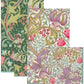 Four overlapping rectangular Caspari Golden Lily Collection biodegradable napkins, featuring intricate green, pink, purple, and cream floral and leaf patterns, are arranged against a white background.
