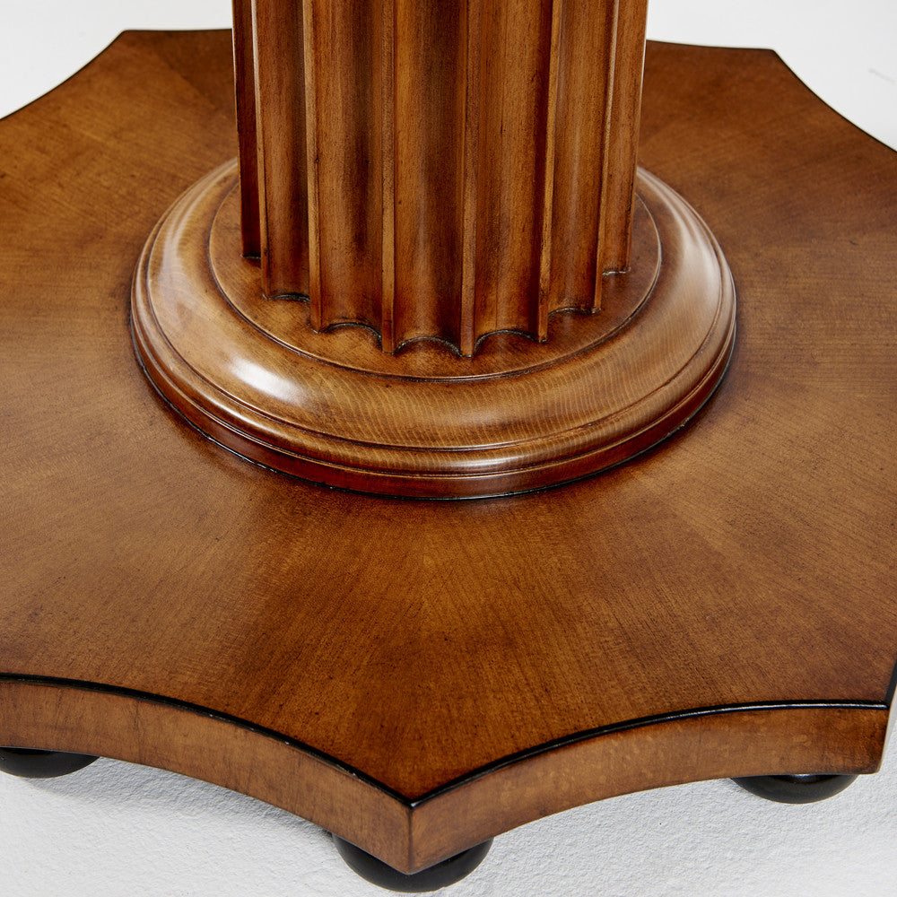 Close-up of the base of the Gottlieb Side Table by Bunny Williams, featuring reeded vertical grooves on its pedestal and an octagonal wooden platform in a rich mahogany finish.