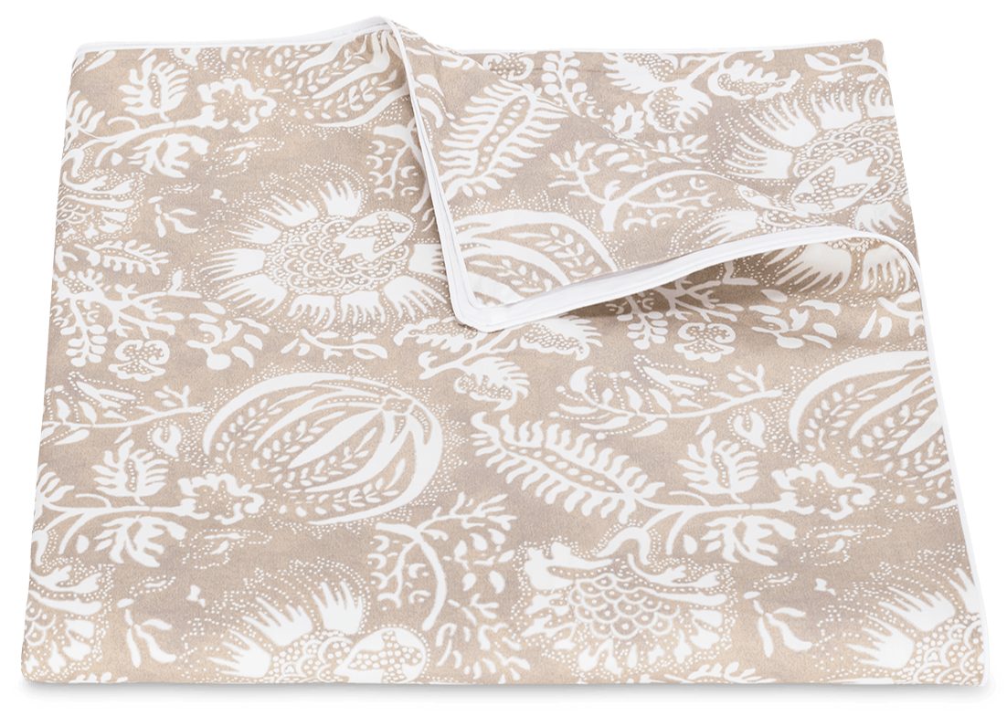 A beige cotton percale fabric featuring a white floral and leaf pattern, displayed on a plain background from the Matouk Granada Bedding Collection in Dune.