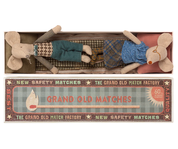 Two whimsical fabric mice, tucked comfortably in a matchbox-style package labeled "Mail Grandma & Grandpa Mice in Matchbox," make for the perfect children's toy by Maileg. Adorned with charming vintage-style design elements, these delightful grandma and grandpa mice will add a touch of nostalgic joy to any child's playtime.