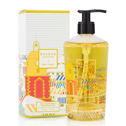 A clear pump bottle from the Baobab Collection Saint Tropez Body Wellness Collection stands beside its vibrant, striped box, evoking the fresh fragrance of a summer perfume.