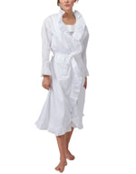 A woman wears the Haute Home Ruffle Robe in 100% white cotton sateen, featuring long sleeves, ruffled trim, a waist tie belt, and a matching nightgown underneath.