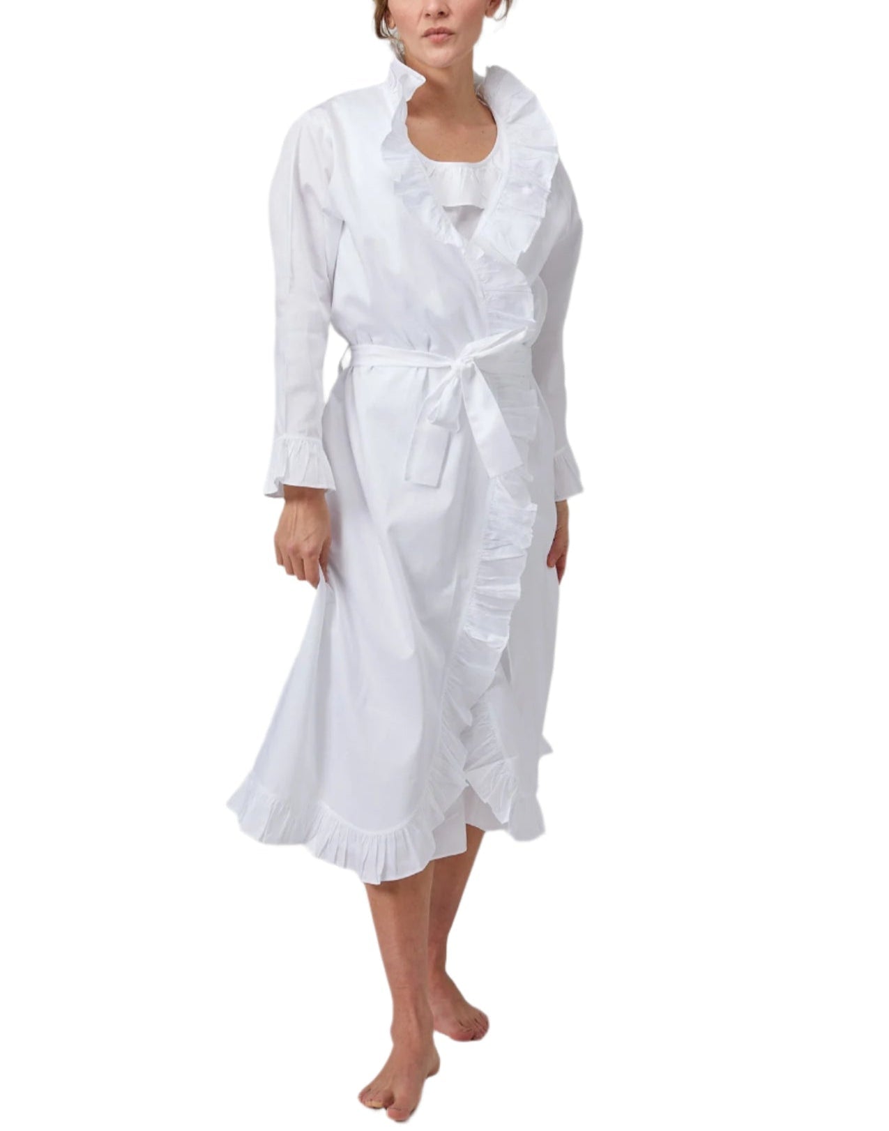 A woman wears the Haute Home Ruffle Robe in 100% white cotton sateen, featuring long sleeves, ruffled trim, a waist tie belt, and a matching nightgown underneath.